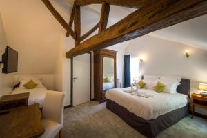 1 dormitorio con 2 camas, escritorio y TV en Domaine de Presle Saumur, The Originals Relais, en Distré