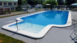 a large swimming pool with chairs around it at Stucco Lodge in Bangor