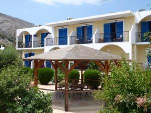 a gazebo with tables and chairs in front of a building at Castellania Hotel Apartments in Livadia