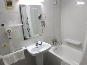 La salle de bains blanche est pourvue d'un lavabo et d'une baignoire. dans l'établissement Hotel Norai, à Lloret de Mar