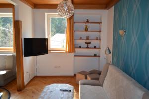 uma sala de estar com um sofá e uma televisão em Luzik Krynica em Krynica-Zdrój