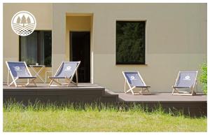 three lounge chairs sitting outside of a building at Górzysta in Gdańsk