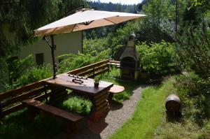 a picnic table and an umbrella in a garden at Luzik Krynica in Krynica Zdrój