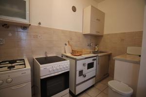 a small kitchen with a sink and a stove at Apartman Anka in Novi Vinodolski