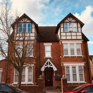 a large red brick house with a black door at Luxurious 2 Bed Apartment in Bedford