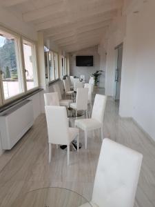 a room with white chairs and tables and windows at Hotel Ristorante Borgo La Tana in Maratea