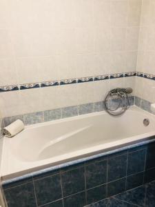 Ubytování Barborka في أولوموك: حوض استحمام أبيض في حمام من البلاط