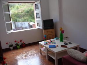 a living room with a table and a window at Casa Estrella in Pravia