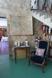 a room with a chair and a table with a map at tempepailla in Roynac