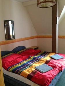 a bed with red sheets and blue towels on it at Panoráma Panzió in Tatabánya