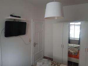 a room with a tv on the wall and a door at Max's Hinterhaus in Dresden