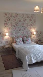 a bedroom with a bed with flowers on the wall at Miramar in Łeba