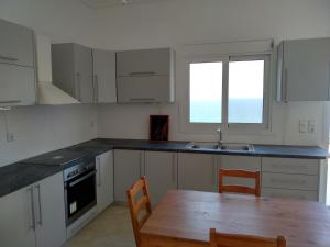 a kitchen with a table and a sink and a window at Kymi Bay House in Platána