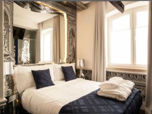 a bed with a white comforter and pillows at Teatro Boutique Rooms & Suites in Lisbon