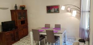 a dining room with a table with chairs and a tv at Au Coeur du vieux Nice in Nice