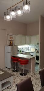 a kitchen with a counter and two red bar stools at Au Coeur du vieux Nice in Nice