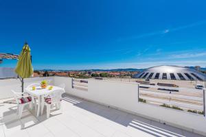 a balcony with a table and a view of a stadium at Apartments HIPERION in Zadar
