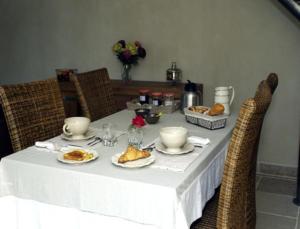 une table avec un tissu de table blanc et de la nourriture dans l'établissement Le Clos Du Murier, à Chassignelles