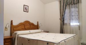 a bedroom with two beds and a window at Hostal Yuste in Garganta la Olla