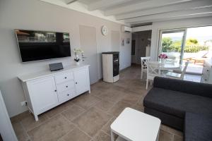 a living room with a couch and a tv and a table at Bianca Dimora in Torre Canne