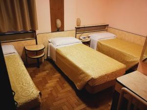 a hotel room with three beds and two chairs at Hotel Ristorante Farese in Melfi