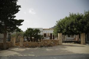 a house with a stone fence and trees at Antico Casale sul Mare in Custonaci