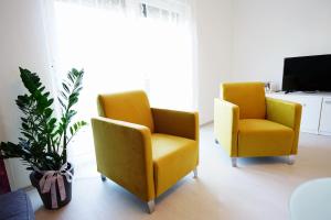 2 sedie gialle in soggiorno con pianta di Casa Gremar a Pješčana Uvala