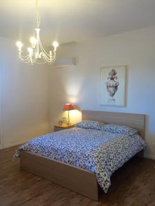 a bedroom with a bed and a chandelier at Casa Vento dello Stagnone in Marsala