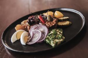 a black plate of food on a table at Strandhotel Sille in Reifnitz