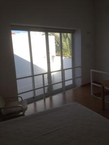 a room with a bed and a large window at CASA NA VILA HISTÓRICA DE MOURÃO in Mourão