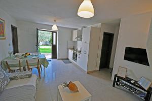 a living room with a couch and a table and a kitchen at Apartment Dva Oriha in Funtana