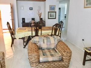a dining room with a rattan table and chairs at Hastings Towers 3B Opp Sea 2 Bed 2 Bath in Bridgetown
