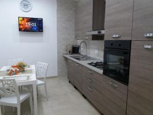 a kitchen with a stove and a sink and a table at La dimora di Vituccio B&B in Avetrana