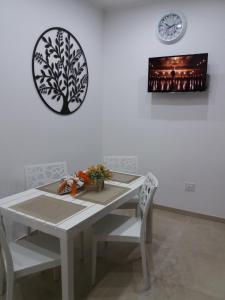 a white table with two chairs and a clock on the wall at La dimora di Vituccio B&B in Avetrana
