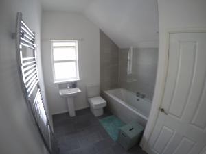 ポーツチュワートにあるPortstewart Holiday Homeのバスルーム(洗面台、トイレ付)、窓が備わります。