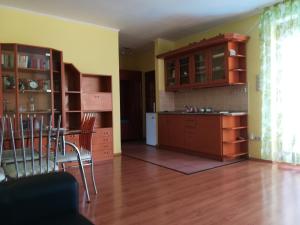 uma cozinha com armários de madeira e uma mesa e cadeiras em Janó Apartman em Siófok