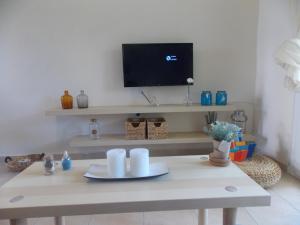 sala de estar con mesa y TV en la pared en Sophia's Apartment, en Skála Foúrkas