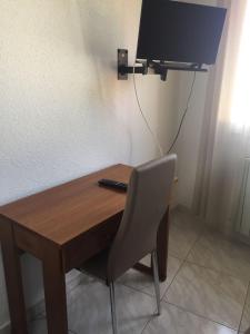 a desk with a chair and a television on a wall at Hotel Meve Mar in Somo