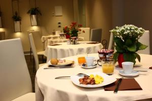パラビアーゴにあるExpo Hotel Milanの食べ物と飲み物の盛り合わせが付いたテーブル