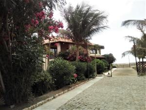 una casa con una palma e una strada di ciottoli di Porto Antigo - Charming & peaceful apartment overlooking pool and sea a Santa Maria
