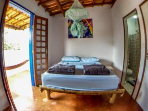 a bedroom with two beds and a mirror at Hospeda Vila in Vale do Capao