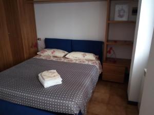 een kleine slaapkamer met een bed met een blauw hoofdeinde bij Casa vacanze Dalia in Marone