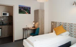 a bedroom with a bed and a desk and a table at Pokoje z aneksami Orla 6 in Lublin