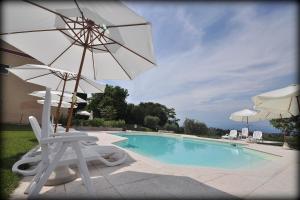 a swimming pool with a chair and an umbrella at Agriturismo Panorama in Castelnuovo del Garda