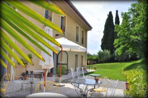 a patio with tables and chairs next to a building at Agriturismo Panorama in Castelnuovo del Garda