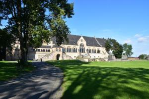un grande edificio in pietra con un albero in primo piano di Bergblüte a Bad Harzburg