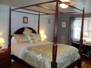 a bedroom with a large bed with a canopy at Abide Within Bed & Breakfast in Truro