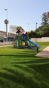 a playground with a slide in a park at Estudio playa Benalmadena in Benalmádena