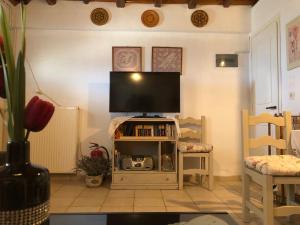 a living room with a flat screen tv on a stand at Eva's House Mouresi in Mouresi