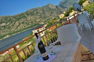 a bottle of wine sitting on a table on a balcony at Apartmani Prcanj in Kotor